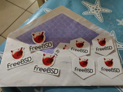 Various FreeBSD stickers on top of the envelope they came in.